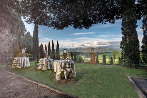 a couple of tables on the grass in a yard at Villa Barberino in Meleto