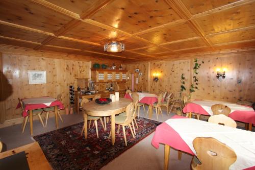 restauracja ze stołami i krzesłami oraz drewnianymi ścianami w obiekcie Pension Mezzaprada w mieście Arosa