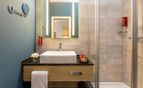 a bathroom with a sink, toilet and bathtub at Leonardo Hotel Budapest in Budapest
