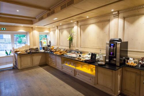 a large kitchen with wooden cabinets and a counter top at Hôtel SPA du Lac de Madine - Maison DRAPIER in Heudicourt-sous-les-Côtes