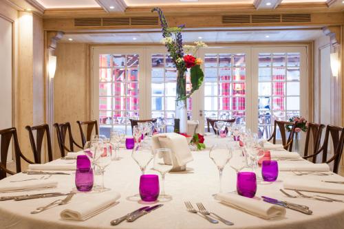 a long table in a room with purple glasses at Hôtel SPA du Lac de Madine - Maison DRAPIER in Heudicourt-sous-les-Côtes