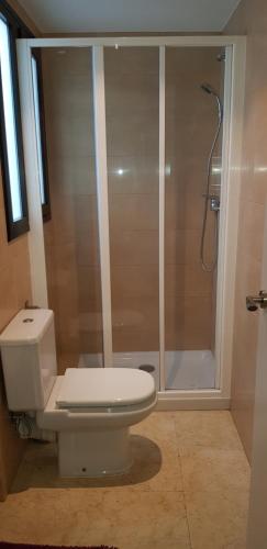 a bathroom with a white toilet and a shower at SUNSET PENTHOUSE SITGES in Sitges