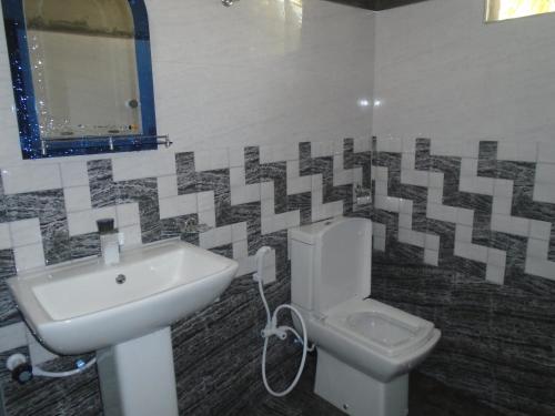 uma casa de banho com um lavatório e um WC em El Shaddai em Manar