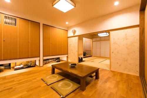 Zimmer mit einem Tisch und einem Zimmer mit einer Tür in der Unterkunft Waso Mukuge in Sakaiminato
