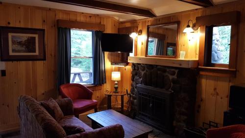 a living room with a fireplace and a couch at The Wilderness Inn: Chalets in Wilmington