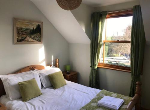 a bedroom with a bed and a window at Lazy Daze Cottage in Horsham