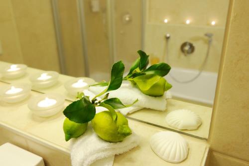 a bathroom counter with pears and towels and a mirror at Hotel Inspiration Garni in Tittmoning