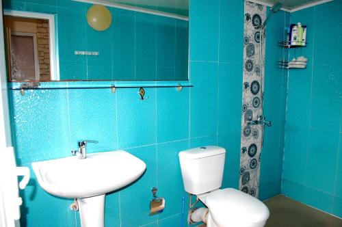 a blue bathroom with a toilet and a sink at Apartment "Ceazars" in K'obulet'i
