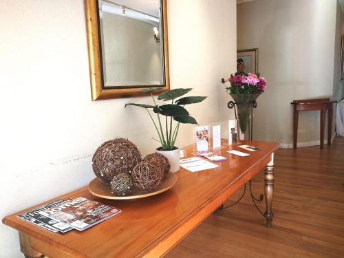 una mesa de madera con un espejo y flores. en Zevenwacht Cottages, en Kuilsrivier