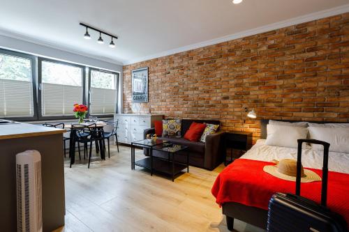 a room with a brick wall and a bed and a kitchen at Apartamenty Przytulne z parkingiem rowerowym, dostępem sauny- bicycle parking and access to the Sauna in Gdańsk