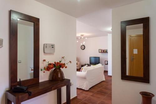 a living room with a mirror and a white couch at Casa Idilica Apartment in Corralejo