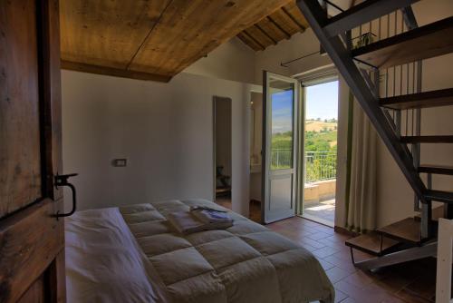 a bedroom with a large bed and a staircase at Casali Marchigiani - Ville vacanza private con piscina in Ostra