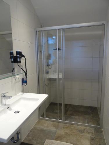 una ducha de cristal en un baño con lavabo en Apart Matt, en Flirsch
