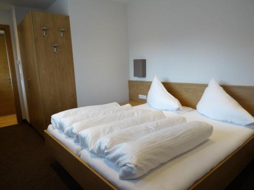 Una cama con mantas blancas y almohadas. en Apart Matt, en Flirsch