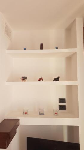 a white wall with shelves with figurines on them at Villetta G in Senigallia