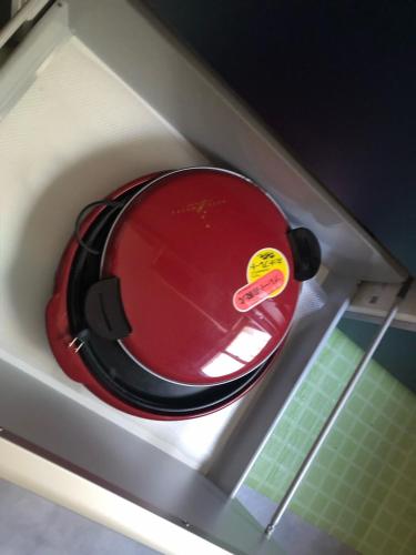 a red frying pan sitting on top of a refrigerator at Forest House Yamanakako in Yamanakako