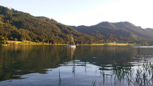 a large lake with a sail boat in the middle at Haus Birke in Weissensee