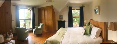 a bedroom with a bed and two chairs in it at Tranquil Water in Midleton