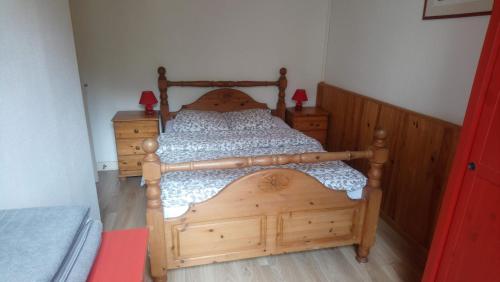 アクス・レ・テルムにあるVilla Margueriteの木製のフレーム付きのベッド(ベッドルーム内)