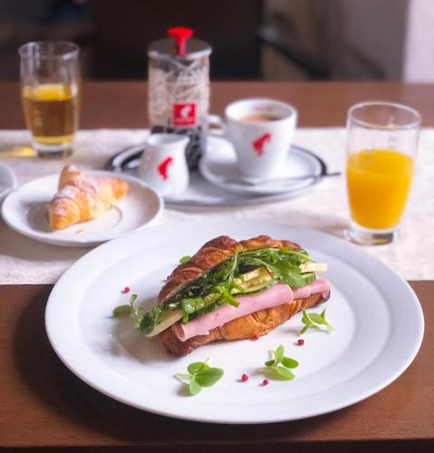 a sandwich on a white plate on a table at Hotel Zámecká Sýpka in Blansko