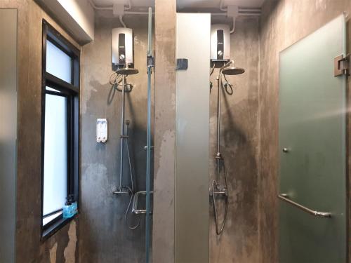 a bathroom with a shower and a glass door at Silom Space Hostel in Bangkok