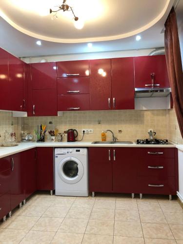 a kitchen with red cabinets and a washing machine at Villa Winery in Cricova
