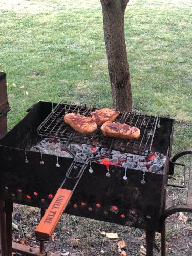three sausages and hamburgers cooking on a grill at Villa Winery in Cricova