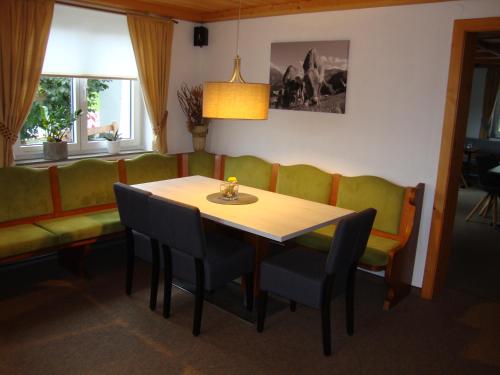 a dining room with a table and chairs and a couch at Weixler Schindelberg in Oberstaufen