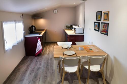 a kitchen with a table and chairs in a room at Appartement La Haute Preze & Golffrance in Rouzède