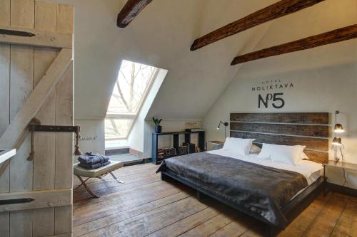 a bedroom with a large bed and a large window at Noliktava No 5 in Kuldīga