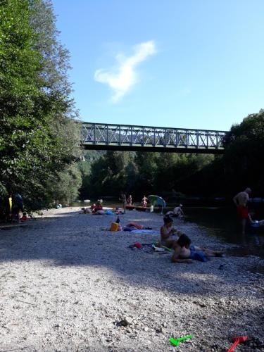a group of people laying on the beach under a bridge at Le Paillier d'Etienne. in La Cresse