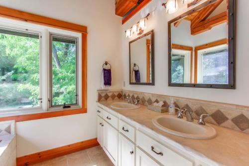 a bathroom with two sinks and two mirrors at Bottle Bay Lakefront Lodge in Sandpoint