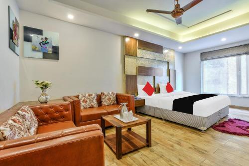 Habitación de hotel con cama y sofá en Staybook Hotel Nitya Maharani en Nueva Delhi