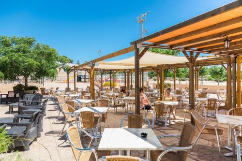 a group of tables and chairs at a restaurant at Comitas Isla del Aire in Punta Prima
