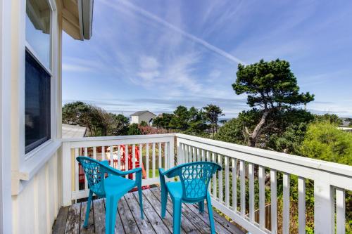 two blue chairs sitting on the porch of a house at The Yellow Rose House in Lincoln City