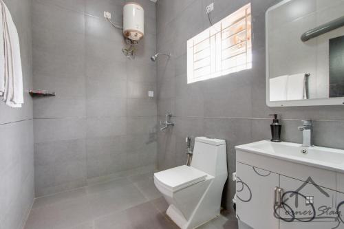 Corner Stay Serviced Apartment-Racecourse في كويمباتور: حمام به مرحاض أبيض ومغسلة