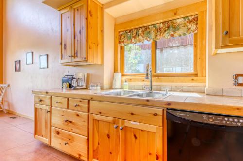 a kitchen with wooden cabinets and a sink and a window at Coyote Run 1 in Moab