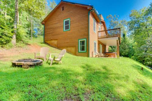 a log cabin with two chairs and a fire pit in the yard at Bears Cove in Sautee Nacoochee