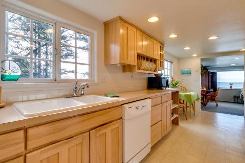 a kitchen with wooden cabinets and a white sink at Hale Kaalawai Unit A in Oceanside