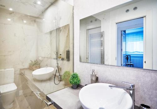La salle de bains blanche est pourvue d'un lavabo et d'un miroir. dans l'établissement VUT San Francisco 3, à Salamanque