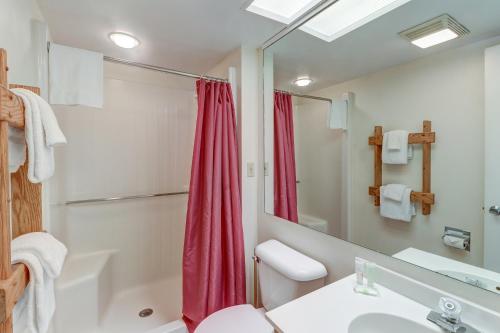 a bathroom with a red shower curtain and a sink at Bridges 35 in Warren