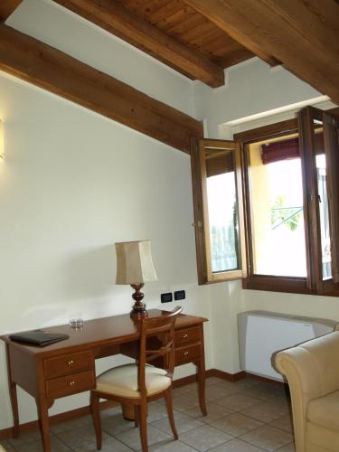 a desk and chair in a room with windows at Hotel Fondo Catena in Ferrara