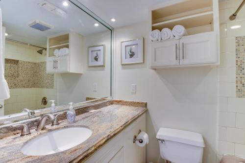 a bathroom with a sink and a toilet and a mirror at Marina Retreat in South Padre Island