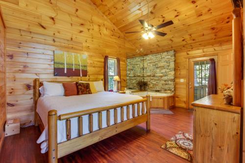 ein Schlafzimmer mit einem Bett in einem Blockhaus in der Unterkunft Dancing Bear in Sautee Nacoochee