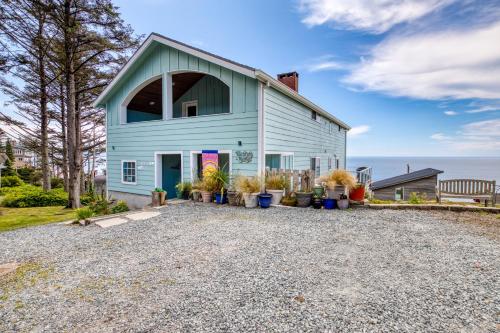 a blue house with potted plants on a gravel driveway at Hale Kaalawai Unit A in Oceanside