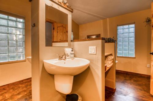 a bathroom with a sink and a mirror at Creekside Cowa-Bungalow! in Moab