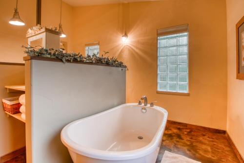 a bath tub in a bathroom with orange walls at Creekside Cowa-Bungalow! in Moab