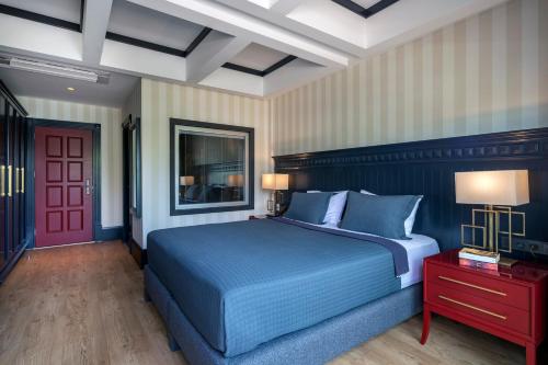 a bedroom with a blue bed and a red door at Hotel Marina Bay Göcek in Göcek