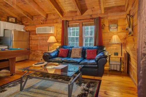 a living room with a leather couch and a table at Shasta in Sautee Nacoochee