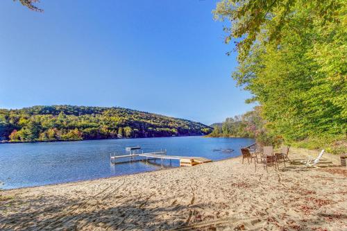 a beach with chairs and a dock on a lake at Birch Landing #16 in Plymouth